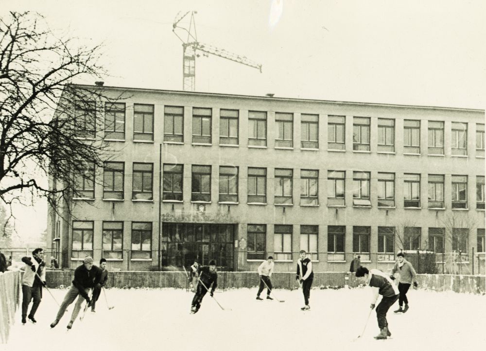 Muži hrající hokej před budovou průmyslové školy v Uherském Hradišti na Kollárově ulici čp. 617 kolem roku 1966. Státní okresní archiv Uherské Hradiště, fond Okresní národní výbor Uherské Hradiště, inv. č. 1016, Přehled o vývoji a zařízení Střední průmyslové školy strojnické Uh. Hradiště.