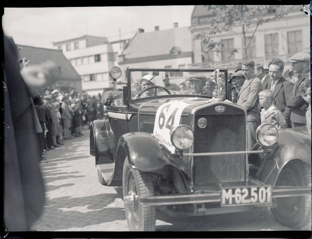 Motoristický sport se ve Zlíně těšil velkému zájmu. Firma Baťa začala ve 30. letech vyrábět automobilové pneumatiky a logicky se zapojila také do pořádání nejrůznějších propagačních akcí, jako byla plaketová jízda Valašskem 21. května 1933. Na snímku projíždí zlínským náměstím její účastnice Marie Zaorálková. Foto: Josef Vaňhara. Státní okresní archiv Zlín, fond Sbírka fotografií Zlín, obálka č. 4221, poř. č. 1.